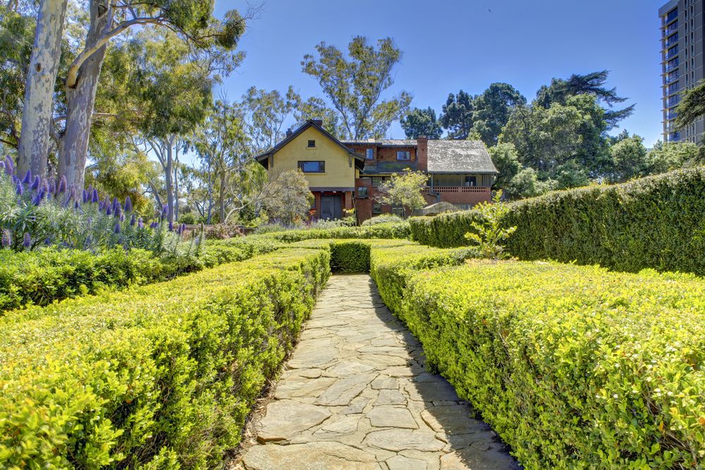 A trail lined with bushes leading to Historic Marston House