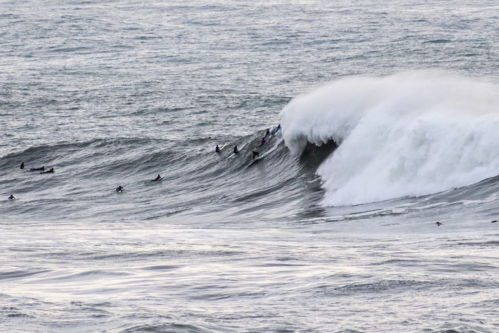 Surfers riding the big waves of Pillar Point