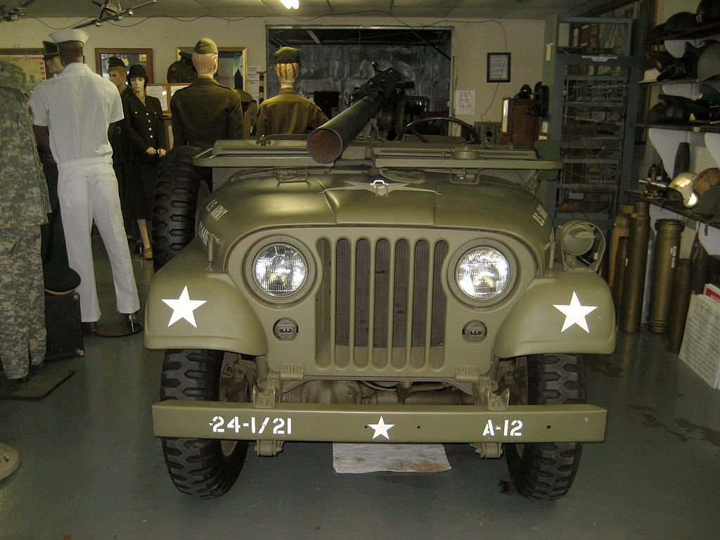 An army green jeep inside the military museum.