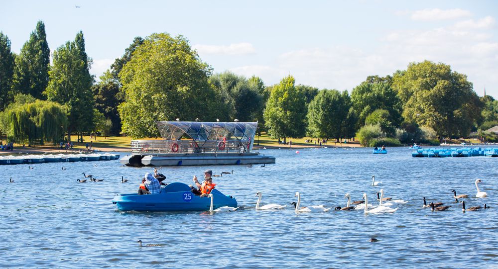People on boats on The Serpentine lake
