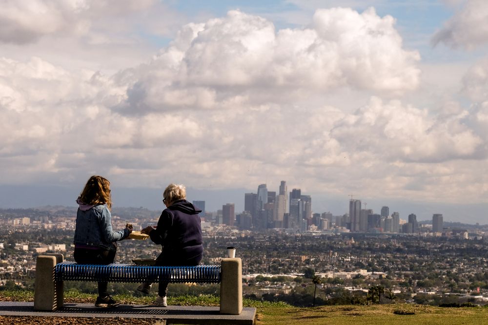 People sitting on a bench overlooking the city at Kenneth Hanh Park