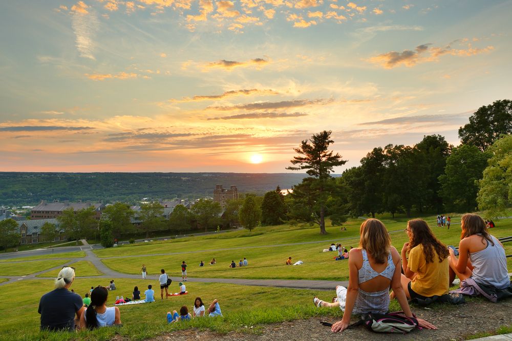 Students watching the sunset at Cornell University's libe slope