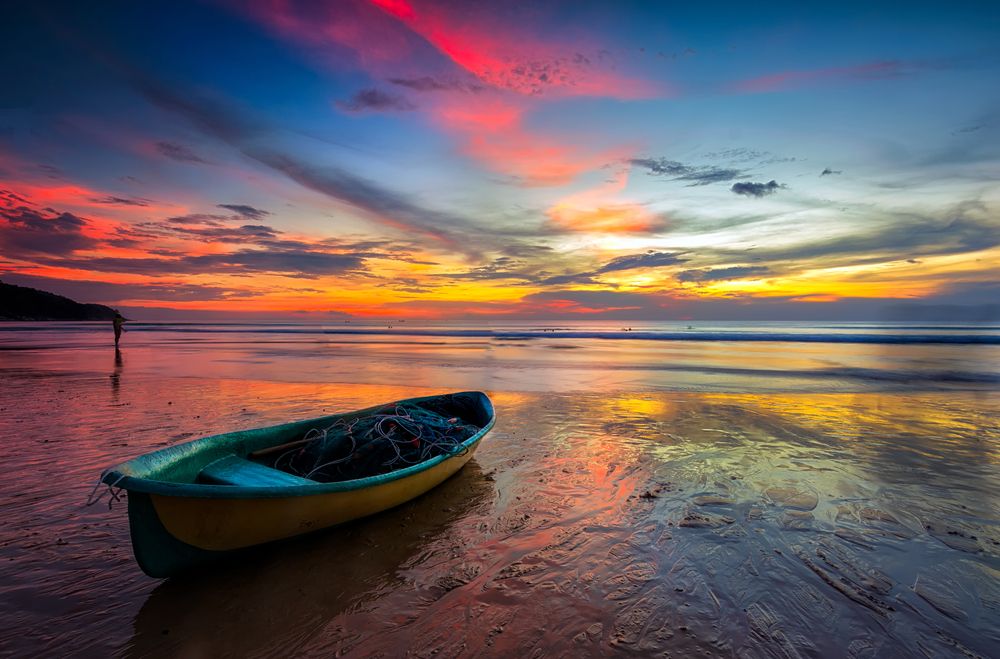 Picturesque Sunsets with a loney boat in the forefront at Karon Beach