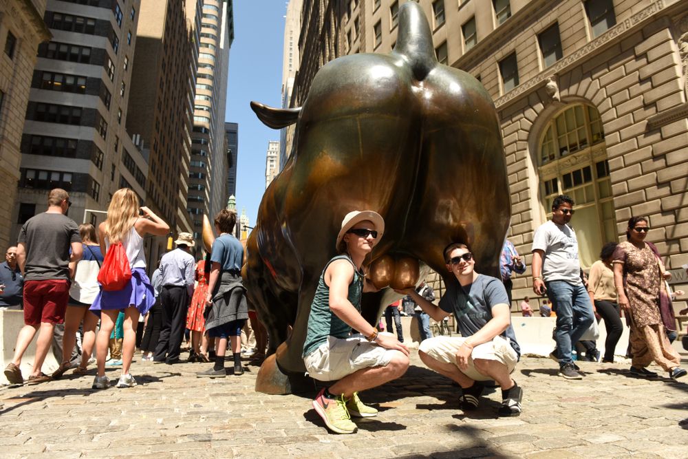 People taking a posing with the Charging Bull