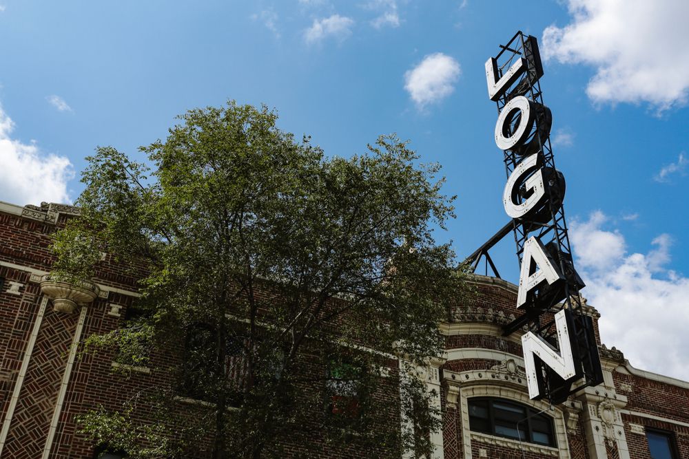Name sign of The Logan Theatre, and a tree.