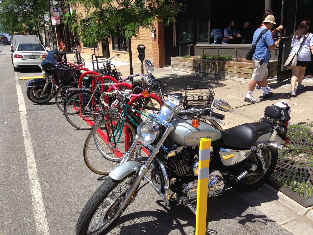 Motorcycles and bikes parked in front of Revolution Brewing - Brewpub.