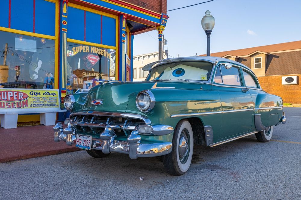 A vintage car parked beside the Super Museum