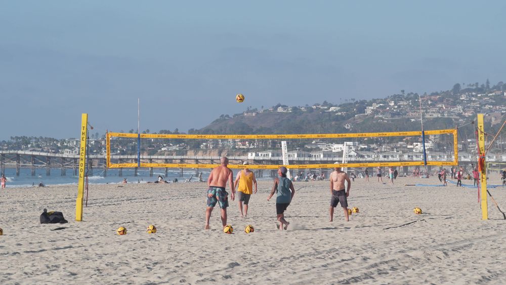 People playing volleyball on mission beach sand