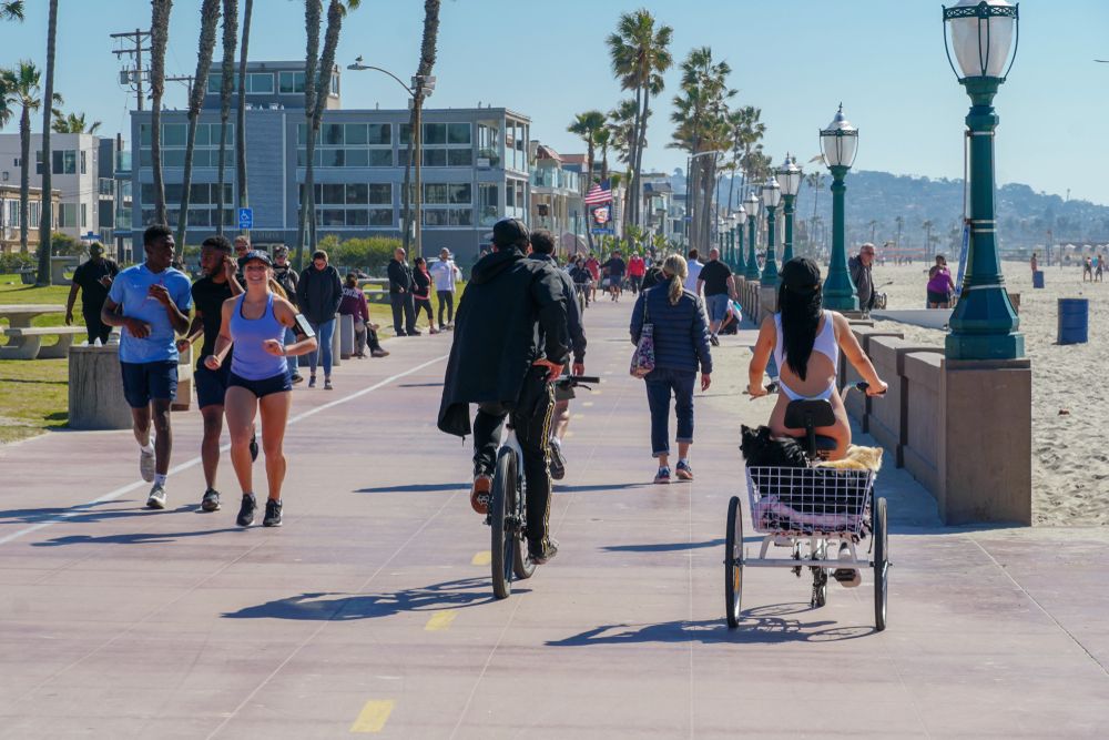 People riding bikes, and walking at mission beach