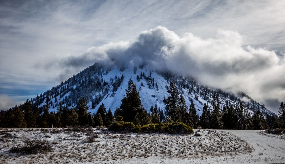 Cloud of smoke coming out of the black butte volcano peak.