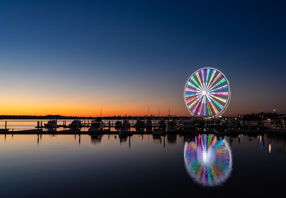 View of Capital Wheel's colorful lights during sunset
