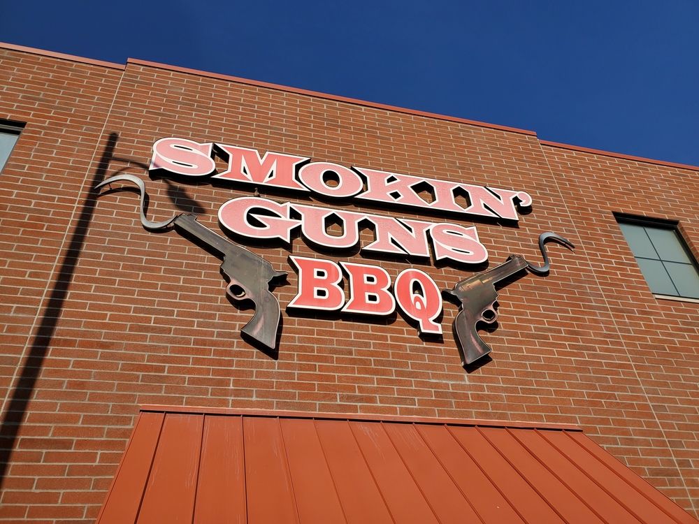 Building sign of Smokin' Guns BBQ