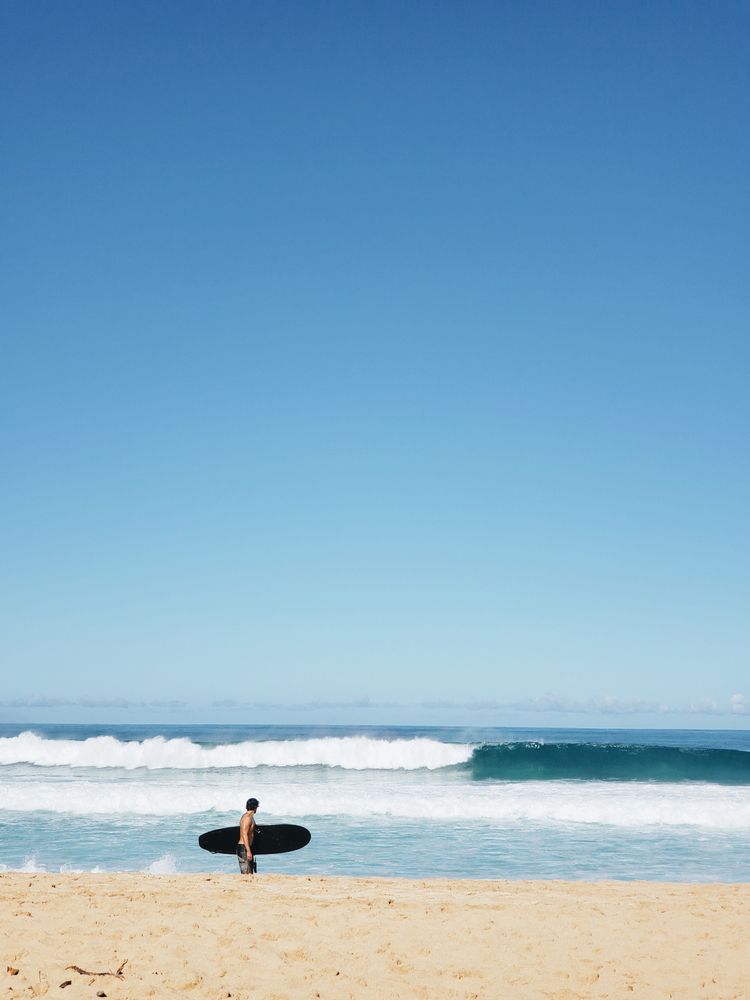 A surfer watching the waves at Banzai Pipeline
