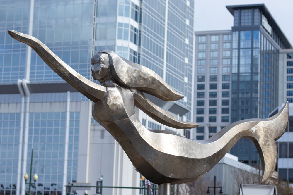 A Norfolk Mermaid Statue in front of a building