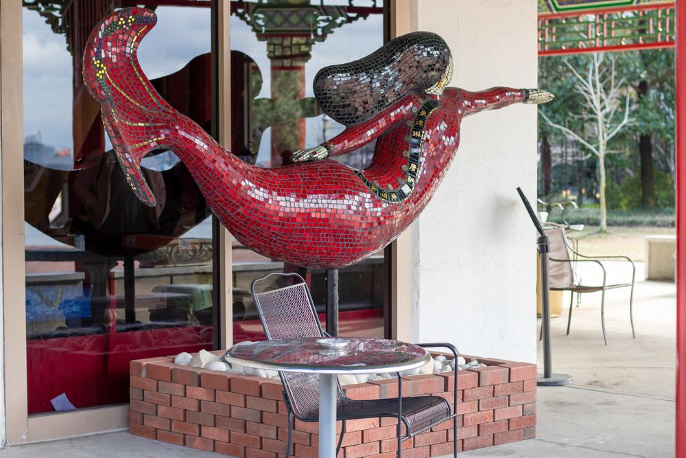 A Norfolk Mermaid Statue in front of an Asian store