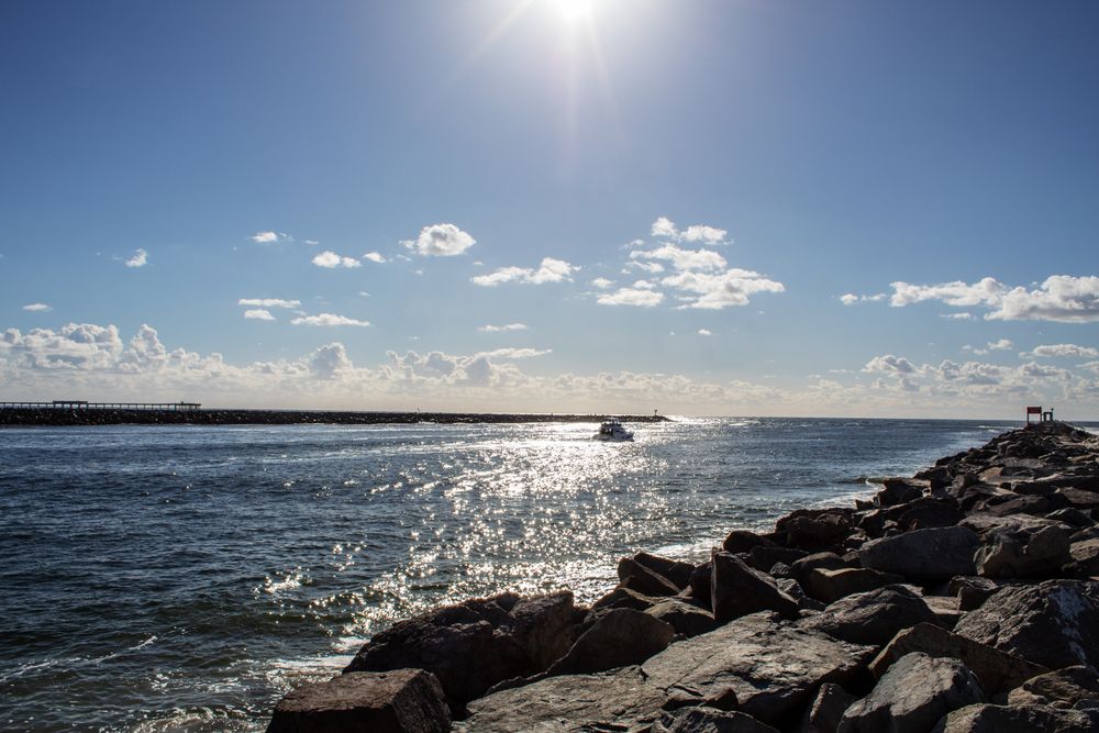 The sun shining down the ocean beach.