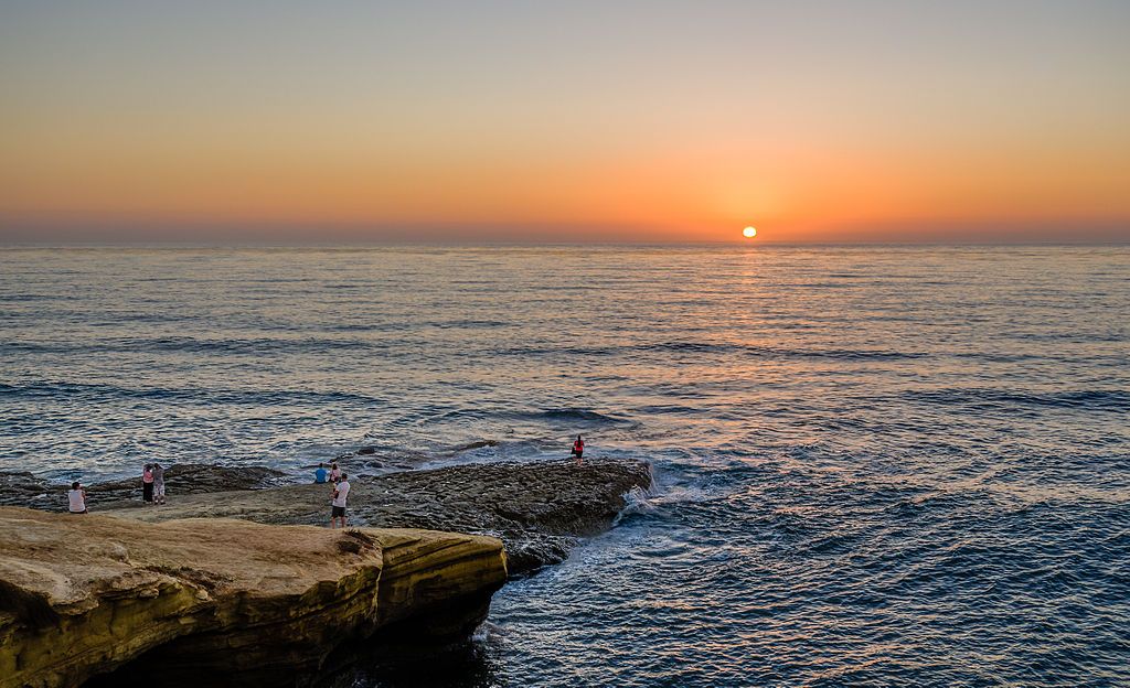 People admiring the sunset at the sunset cliffs national park.