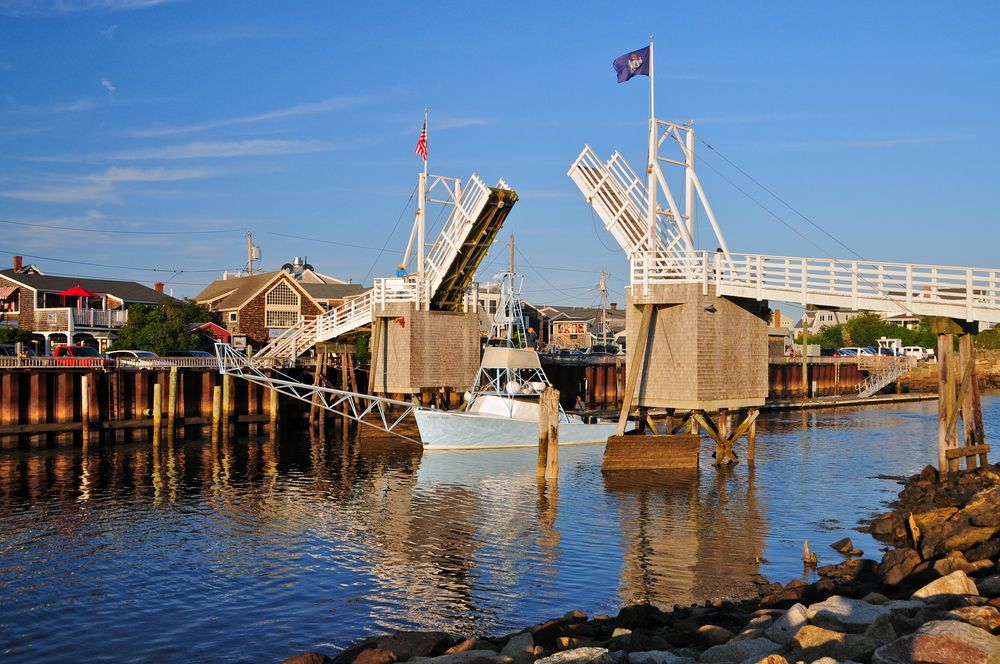 The lifted Perkins Cove bridge with a sailboat passing under