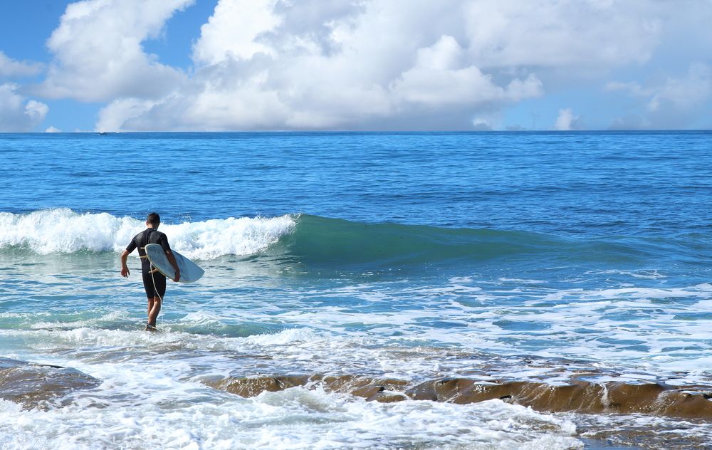 A person about to surf in Pacific Beach