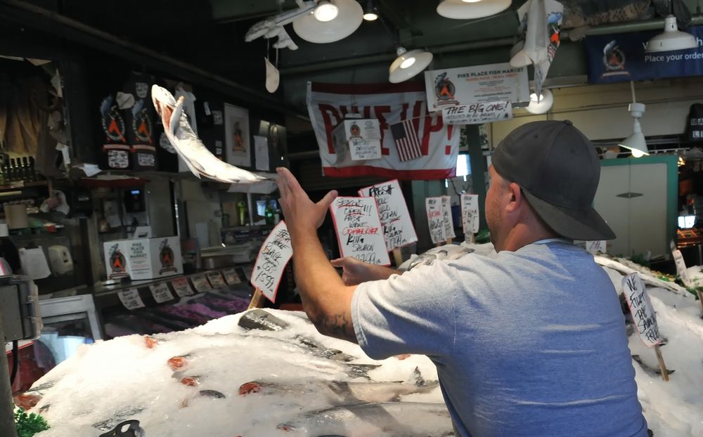 A man tossing a fish at Pike Place Fish