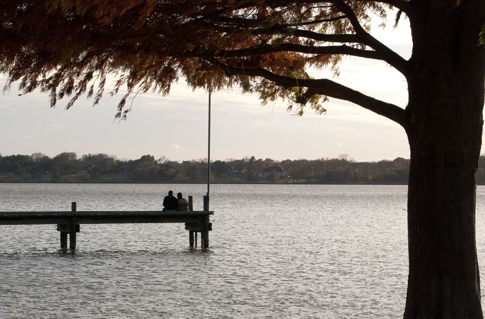 Couple watching the sunset from White Rock Lake's dock