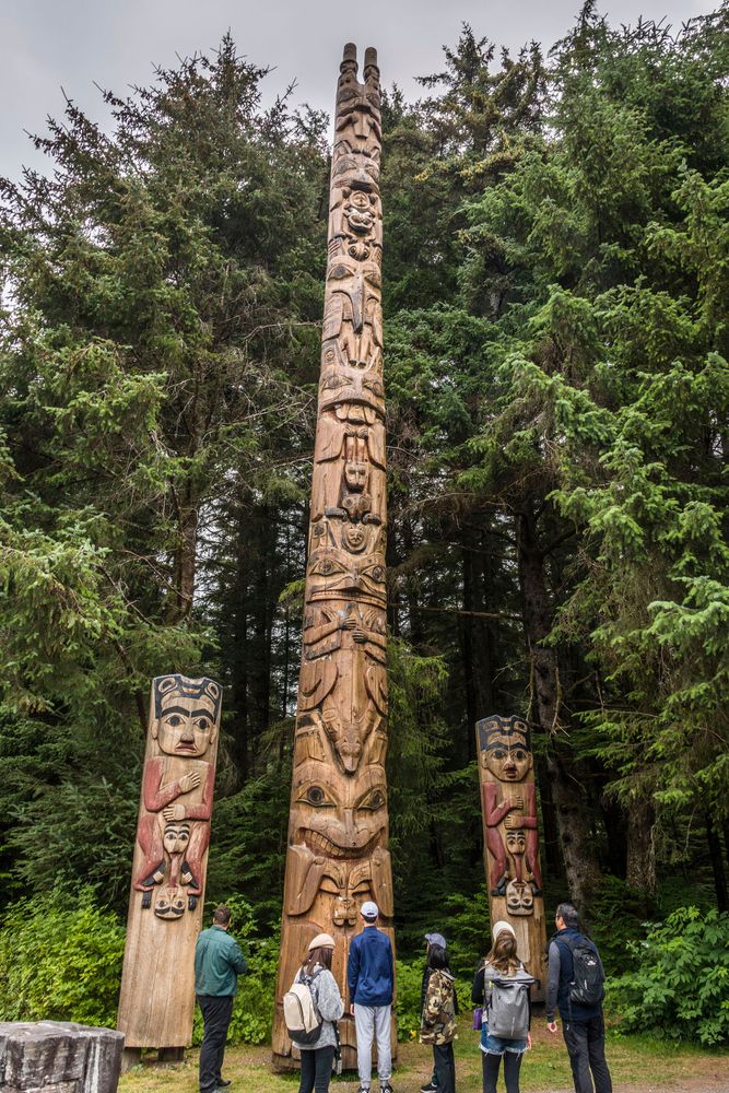 Tourists admiring Sitka National Historical Park's totem pole