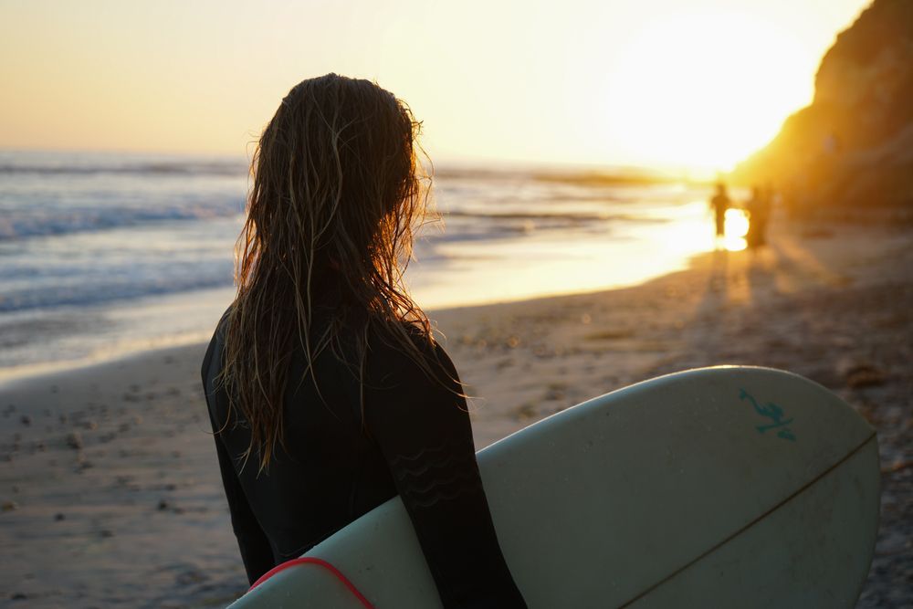 A woman with surfboard at Point Loma