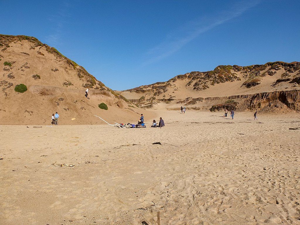 People strolling around the sand of Fort Ord state park.