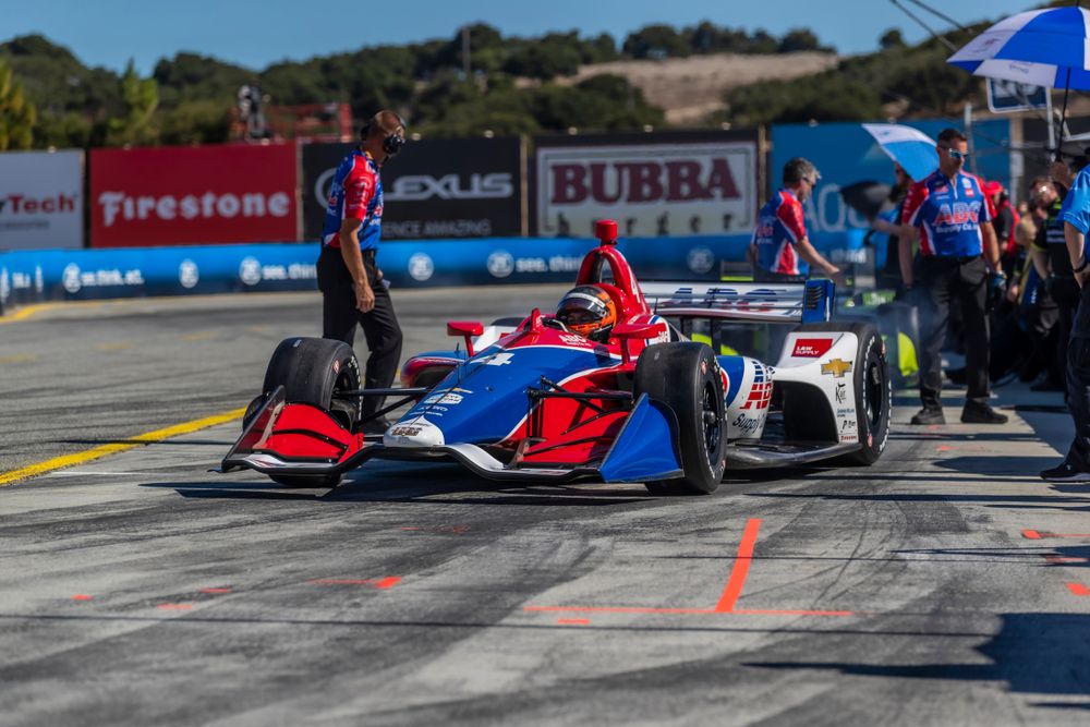 Blue, red and white colored racecar parked on the raceway.