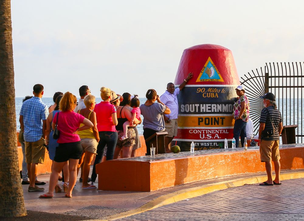 People Taking Picture With the Southernmost Point Marker in Key West in Sunset