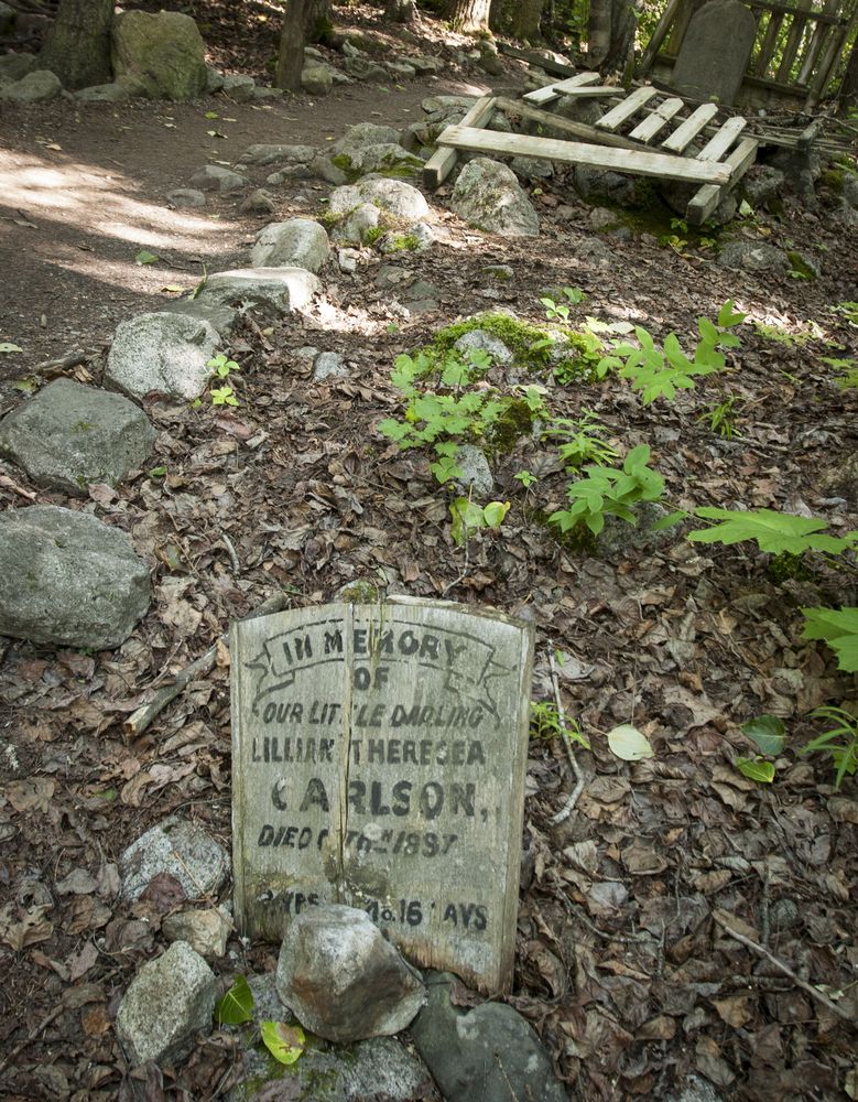 Rocks and dried leaves around a headstone