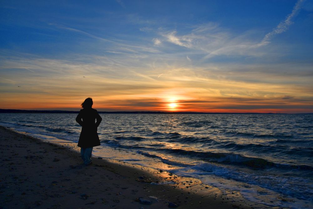Woman admiring the sunset at West Meadow Beach
