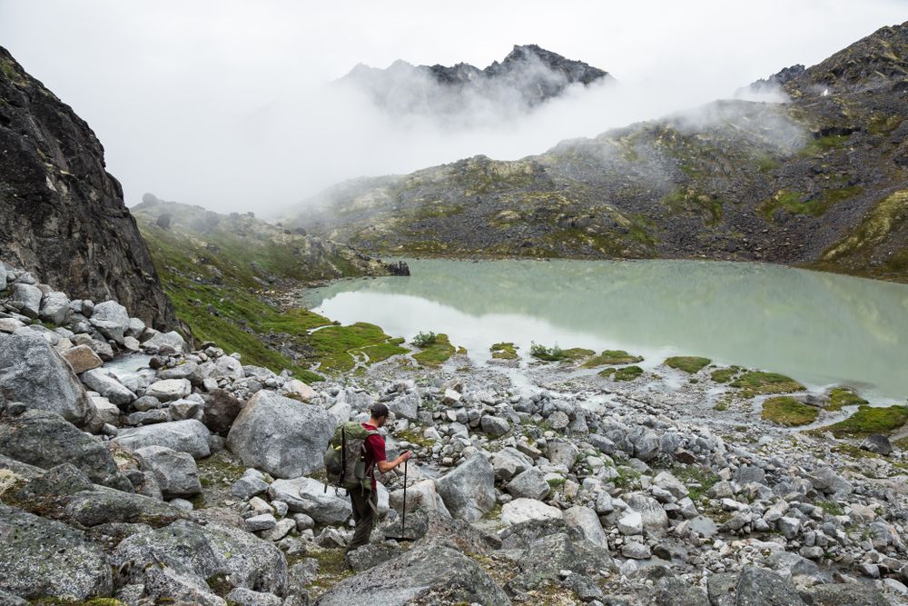 A hiker walking down a rocky trail at Talkeetna