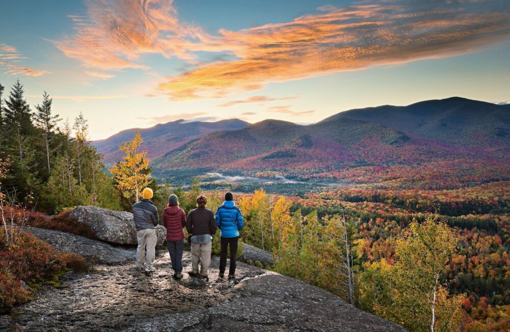 Four hikers look out over autumn-colored mountains in upstate New York